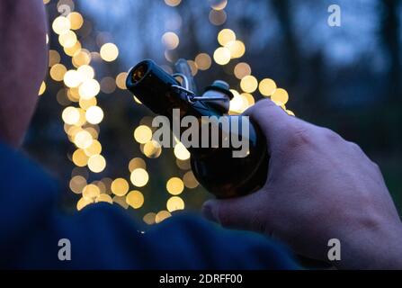 Remscheid, Allemagne. 30 novembre 2020. Un homme tient une bouteille de bière dans sa main (scène posée). En Rhénanie-du-Nord-Westphalie, les réunions de groupe étaient presque universellement possibles, puisque, selon le paragraphe 7 de l'ordonnance sur la protection de Corona, les offres d'auto-assistance appartiennent aux "autres offres d'éducation parascolaires". Néanmoins, les groupes d'auto-assistance de toxicomanie ont également utilisé et utilisent encore d'autres moyens de communication dans de nombreux endroits. Du téléphone, aux groupes de type « whats-App », aux chats ou aux visioconférences. (À dpa 'addiction self-help de plus en plus de crédit: dpa/Alay Live News Banque D'Images