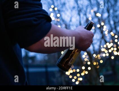 Remscheid, Allemagne. 30 novembre 2020. Un homme tient une bouteille de bière dans sa main (scène posée). En Rhénanie-du-Nord-Westphalie, les réunions de groupe étaient presque universellement possibles, puisque, selon le paragraphe 7 de l'ordonnance sur la protection de Corona, les offres d'auto-assistance appartiennent aux "autres offres d'éducation parascolaires". Néanmoins, les groupes d'auto-assistance de toxicomanie ont également utilisé et utilisent encore d'autres moyens de communication dans de nombreux endroits. Du téléphone, aux groupes de type « whats-App », aux chats ou aux visioconférences. (À dpa 'addiction self-help de plus en plus de crédit: dpa/Alay Live News Banque D'Images