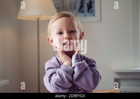 Portrait de bébé garçon mignon souriant avec talc poudre sur le visage