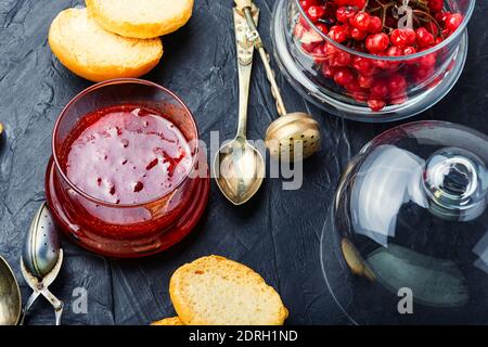 Pot en verre avec confiture et baies de viburnum fraîches Banque D'Images