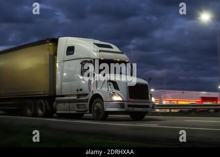 Le camion se déplace sur la route de campagne la nuit Banque D'Images