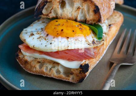 Saumon frais, sandwich aux œufs, gros plan. Saumon salé, œuf frit, beurre et pain blanc sur l'assiette Banque D'Images