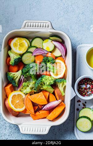 Légumes crus hachés - patates douces, courgettes, brocoli et carottes dans un plat rôti. Cuisson des légumes au four. Cuisine saine FO Banque D'Images