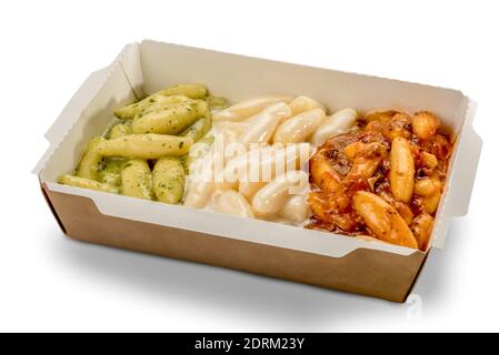 Gnocchi de pomme de terre dans une boîte en carton à emporter recouverte de sauce tomate, de fromage fondu et de pesto génois. Vert blanc et rouge imitent le drapeau italien Banque D'Images