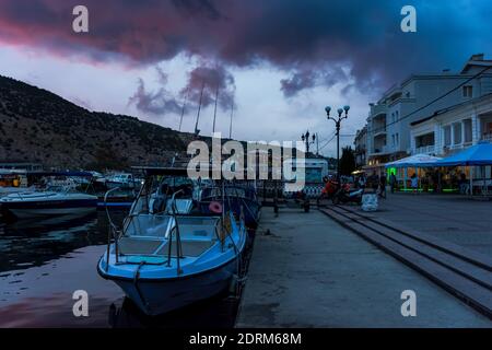 Coucher de soleil à Balaklava Crimée le 04 septembre 2020. Navires dans la soirée dans la baie de Balaklava. Crépuscule paysage urbain nuageux. Bateaux de plaisance dans le Banque D'Images