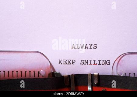 Toujours garder une phrase souriante écrite avec une machine à écrire. Banque D'Images