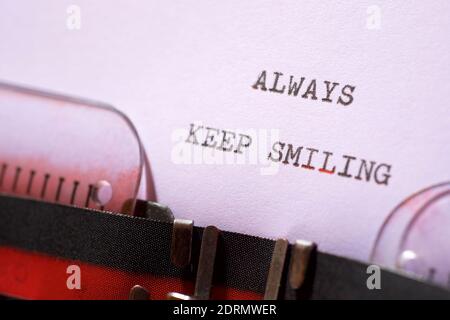 Toujours garder une phrase souriante écrite avec une machine à écrire. Banque D'Images