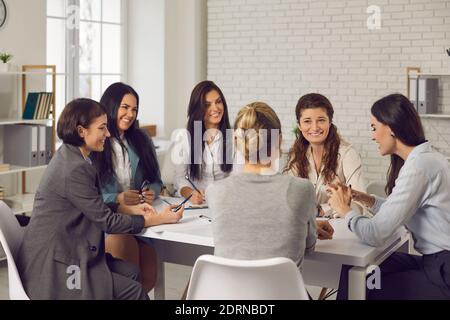 Groupe de femmes d'affaires assis autour de la table, planifiant un nouveau projet et discutant des idées Banque D'Images