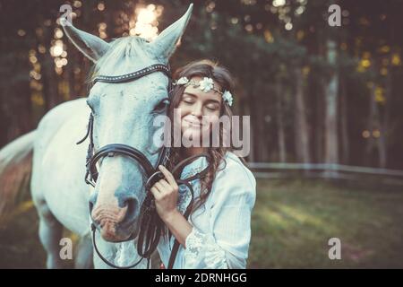 Jeune femme en belle robe blanche et son beau cheval Banque D'Images