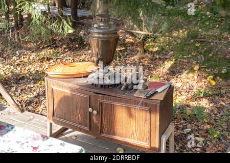 Un dispositif pour faire bouillir l'eau et faire du thé. Samovar russe traditionnel sur une table en bois sur fond de nature. Photo de haute qualité Banque D'Images