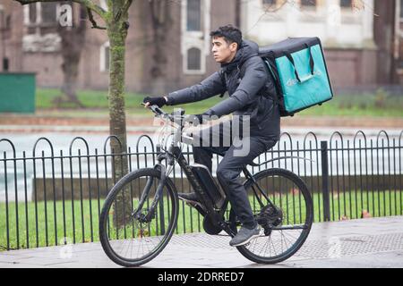 Clapham, Londres, 21 décembre 2020 : les gens font la queue sous la pluie pour récupérer les commandes de Noël d'un boucher local. En vertu des restrictions de niveau 4 du coronavirus, les gens doivent rester à la maison sauf pour les achats essentiels et aller au travail. Les cafés et les restaurants sont ouverts uniquement pour les plats à emporter et Deliveroo propose des produits d'épicerie ainsi que des repas chauds. Anna Watson/Alay Live News Banque D'Images