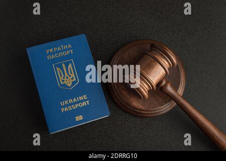 Passeport ukrainien et juge Gavel sur fond gris noir. Immigration légale. Obtenir la citoyenneté Banque D'Images