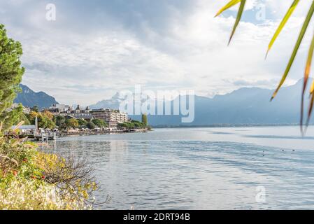 Bord de lac alpin entouré de sommets enneigés et d'une ville sur la rive. Montreux, Lac de Genève en Suisse Banque D'Images