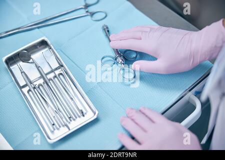 Dentiste utilisant des instruments stériles pendant le travail au bureau Banque D'Images