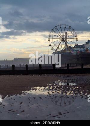 Vue d'hiver sur la plage à Bridlington une station balnéaire populaire dans l'East Riding de Yorkshire Angleterre au Royaume-Uni avec grande roue au loin. Banque D'Images