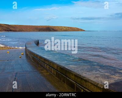 Vagues et la promenade à marée haute sur la plage À Filey, une station balnéaire populaire dans le North Yorkshire Côte dans le nord de l'Angleterre du Royaume-Uni Banque D'Images