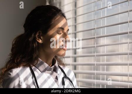 Gros plan d'une femme heureuse médecin détendez-vous avec les yeux fermés Banque D'Images