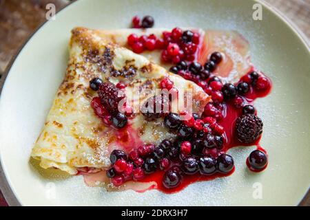 Une crêpe maison servie avec du miel et des fruits surgelés décongelés dans un supermarché. Angleterre GB Banque D'Images