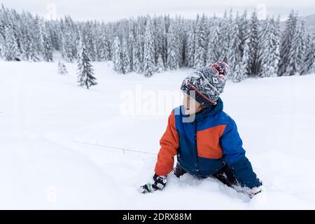 Jour d'hiver, beaucoup de neige, un garçon souriant qui pose dans la neige Banque D'Images
