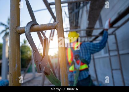 Travailleur de la construction portant un harnais de sécurité et une ligne de sécurité travaillant en position haute, dispositif antichute pour travailleur avec crochets pour harnais de sécurité o Banque D'Images