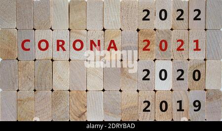 Symbole de la pandémie de Covid-19 en 2021. Les blocs en bois forment les mots 'corona 2021'. Numéros 2019, 2020, 2021. Magnifique arrière-plan en bois. Volet Covid-19 Banque D'Images