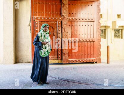 Nizwa, Oman, le 2 décembre 2016 : une femme locale d'âge moyen traverse les portes de la ville au marché du vendredi à Nizwa, Oman Banque D'Images