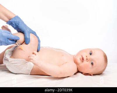 Pédiatre ou infirmière donnant une injection intramusculaire d'un vaccin À la jambe du bébé garçon pendant la pandémie du coronavirus COVID-19 Banque D'Images