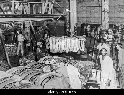 1940 photo d'archives en noir et blanc montrant les ouvriers afro-américains noirs préparant des balles lourdes de coton pour le transport par navire, Texas, États-Unis Banque D'Images