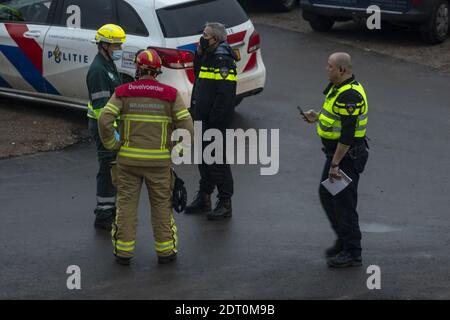 ZUTPHEN, PAYS-BAS - 08 décembre 2020 : commandant du service des incendies et officiers de police dans des masques délibératant et organisant sur une scène d'accident avec Banque D'Images