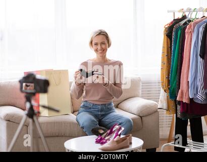 Blog de mode. Une jeune femme vlogger enregistre de nouvelles vidéos sur l'appareil photo à la maison, en faisant un examen des styles et des tendances modernes Banque D'Images
