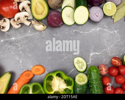 Les légumes frais sont disposés sur la table comme arrière-plan avec un espace pour le texte. Cadre de légumes, paprika, pommes de terre, oignons, carottes, courgettes, mus Banque D'Images