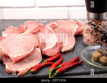 Steaks de porc frais. Viande et piments forts et gros sel de mer Banque D'Images