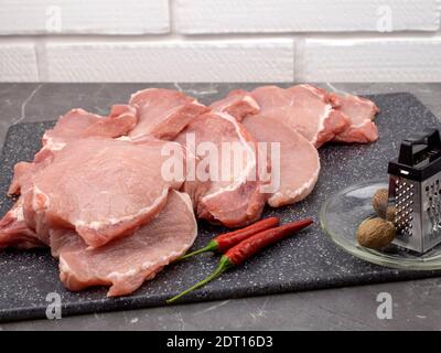 Steaks de porc frais. Viande et piments forts et gros sel de mer Banque D'Images