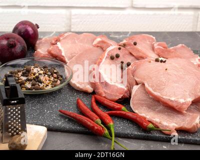 Steaks de porc frais. Viande et piments forts et gros sel de mer Banque D'Images