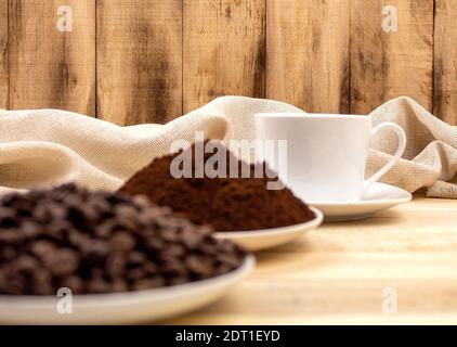 Trois étapes de préparation du café moulu, du grain, de la boisson. Ingrédients du café. Grains de café torréfiés sur le fond des tasses avec du café Banque D'Images