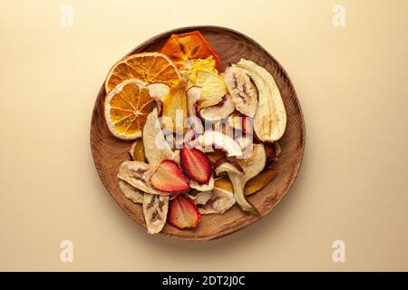 Copeaux de fruits séchés sur une assiette en bois. Le concept d'une collation saine sans sucre, dessert pour les végétariens. Copier l'espace. Banque D'Images