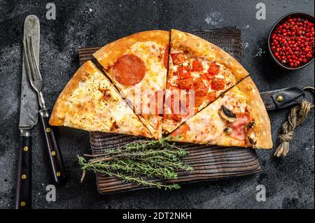 Ensemble de différentes tranches de pizza. Arrière-plan noir. Vue de dessus. Banque D'Images