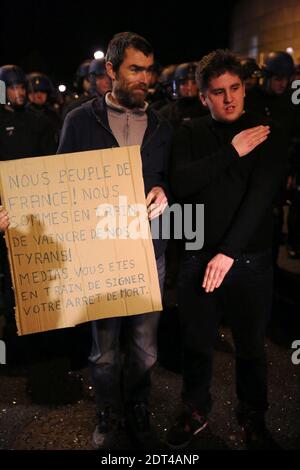 Les personnes rassemblées à la salle de concert du Zénith les huttes et les chants le nom de Dieudonne comme police sont déployées par mesure de précaution à la salle de concert du Zénith à Nantes, dans l'ouest de la France, le 9 janvier 2014. La plus haute cour de France a rétabli une interdiction sur un spectacle de la bande dessinée controversée Dieulonne m'bala m'bala, juste avant qu'il ne soit dû ouvrir. Le ministre de l'intérieur Manuel Valls a appelé le Conseil d'Etat à intervenir quelques minutes après qu'un juge de la ville de Nantes ait renversé l'interdiction. La bande dessinée a sept convictions pour un discours de haine antisémite. Il est déjà arrivé au théâtre de Nantes, où plus de 5,000 p. Banque D'Images