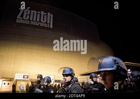 Les personnes rassemblées à la salle de concert du Zénith les huttes et les chants le nom de Dieudonne comme police sont déployées par mesure de précaution à la salle de concert du Zénith à Nantes, dans l'ouest de la France, le 9 janvier 2014. La plus haute cour de France a rétabli une interdiction sur un spectacle de la bande dessinée controversée Dieulonne m'bala m'bala, juste avant qu'il ne soit dû ouvrir. Le ministre de l'intérieur Manuel Valls a appelé le Conseil d'Etat à intervenir quelques minutes après qu'un juge de la ville de Nantes ait renversé l'interdiction. La bande dessinée a sept convictions pour un discours de haine antisémite. Il est déjà arrivé au théâtre de Nantes, où plus de 5,000 p. Banque D'Images