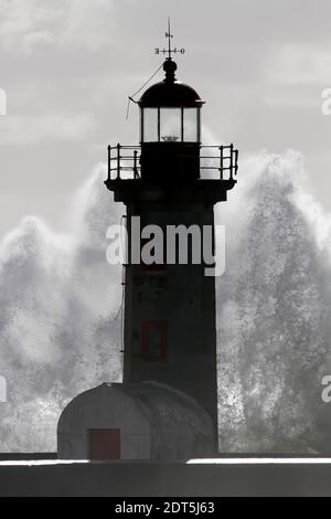 Ancien phare rétroéclairé et nouveau phare de la rivière Douro bouche pendant la tempête Banque D'Images