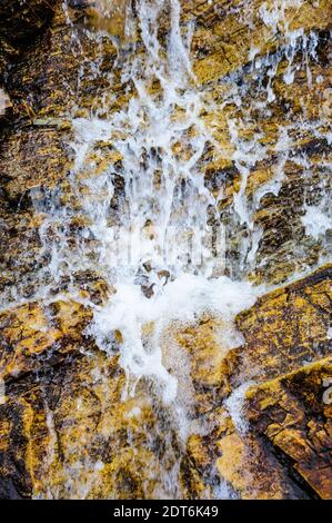Projection d'eau sur une surface rocheuse inégale. Banque D'Images