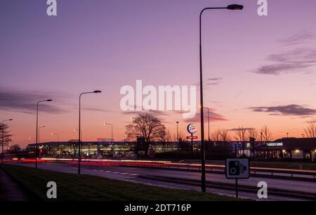 Décembre, l'aube se brise au-dessus de l'Écosse du Nord-est, illuminant les gratte-ciel de la ville urbaine avec un lever de soleil éclatant et coloré à travers le parc commercial Kingsway West à Dundee, au Royaume-Uni Banque D'Images