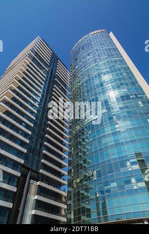 Lave-glaces suspendus à des cordes à l'extérieur d'une tour moderne en verre architectural incurvé et en acier, tel Aviv, Israël Banque D'Images