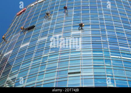 Lave-glaces suspendus à des cordes à l'extérieur de la tour de bureau Reit moderne en verre et en acier, tel Aviv, Israël Banque D'Images