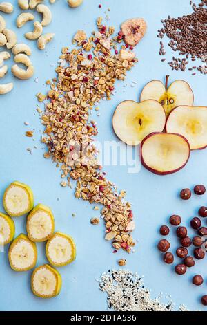 Petit déjeuner sain. Granola aux framboises, graines de sésame noir et blanc, graines de lin, noix de cajou, noisettes, quartiers de pomme et banane. Conce alimentaire sain Banque D'Images