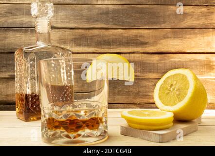 Cognac en carafe et citron sur fond de bois Banque D'Images