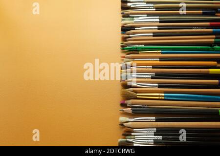 Crayons et pinceaux dans l'atelier de l'artiste sur la table. Vide pour le texte. Banque D'Images