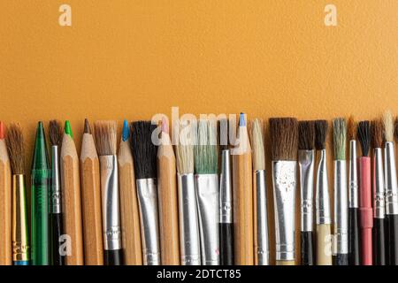 Crayons et pinceaux dans l'atelier de l'artiste sur la table. Vide pour le texte. Banque D'Images