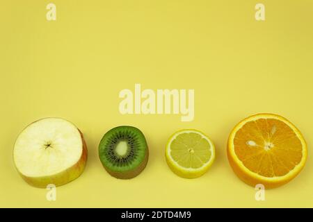 Fruits placés sur une planche pour le fond. Des morceaux de kiwi et de pomme, de banane et d'orange sont disposés sur la table pour le fond avec du texte Banque D'Images