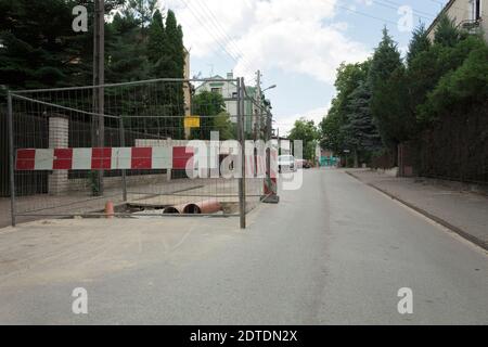 La tranchée est sur la route et est clôturée. Travaux de réparation. Réparation des communications dans la ville Banque D'Images